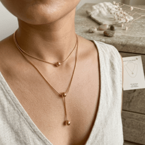 A beautiful Pakistani actress styling an adjustable gold-plated lariat snake chain necklace with smooth sliding ball beads.