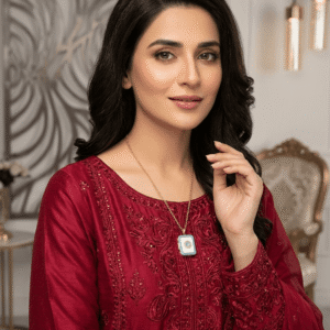 A beautiful Pakistani actress in a red embroidered dress wearing a vintage gold and turquoise evil eye book pendant necklace.