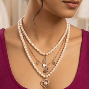 A beautiful Pakistani actress in a magenta dress wearing a double-layered gold and pearl necklace with a rhinestone heart pendant.