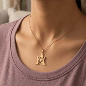 A beautiful Pakistani actress styling a gold plated stainless steel initial letter 'A' pendant necklace with a butterfly overlay.