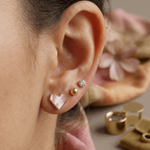 Gold Pink Heart and Crystal Stud Earring Set styled on a model's multi-pierced ear.