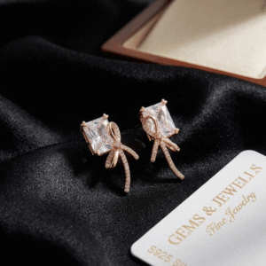 S925 Silver Rose Gold Ribbon Bow Crystal Earrings displayed on black satin.