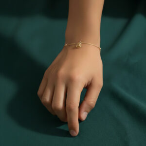 Woman wearing a gold rose charm bracelet with delicate beaded chain